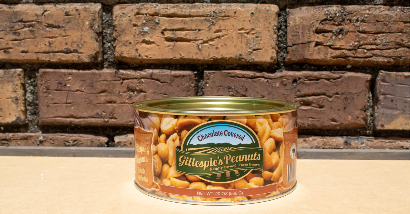 A can of Chocolate Covered peanuts on a brick ledge